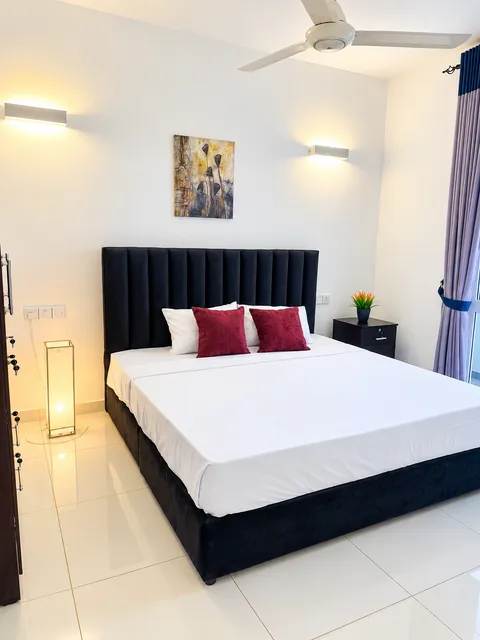 Double bed with bedside lamps and dark headboard